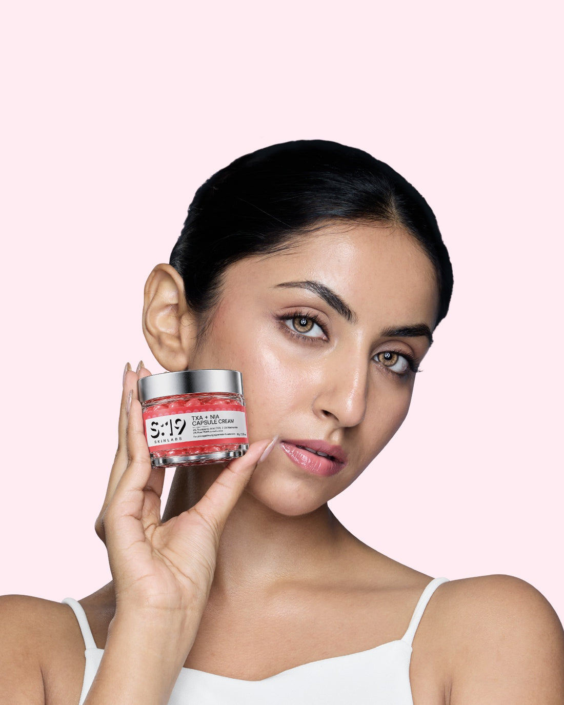 Model holding S19 TXA + NIA Capsule Cream for pigmentation and uneven skin tone