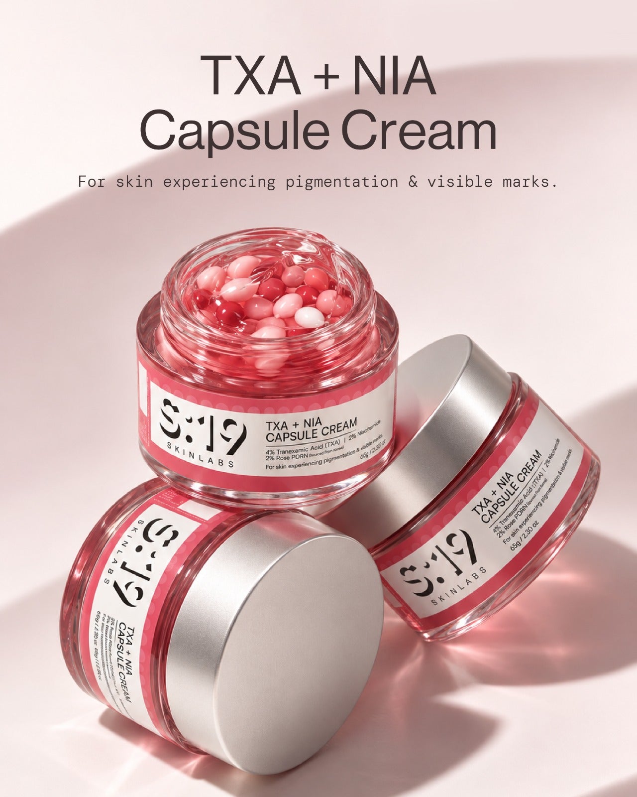 TXA + NIA Capsule Cream open jars showing pink tranexamic acid and niacinamide capsules